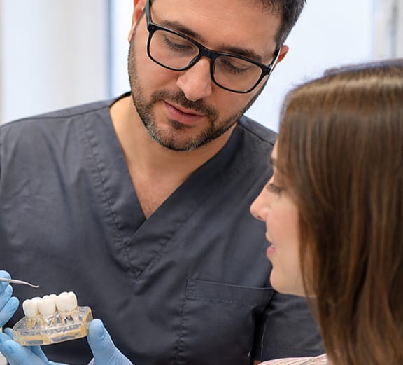 Restorative dentistry consultation with a dental restoration model